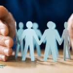 Hands protecting paper cutout people, showing employee background verification and workplace safety.